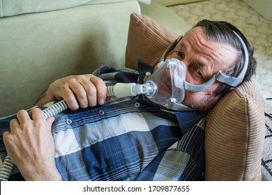 Coronavirus Patient Elderly Man In Oxygen Mask In Bed At Home