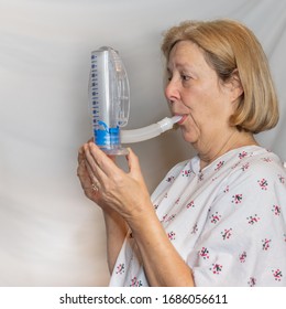 Coronavirus Patient With A Lung Disease Using A Volumetric Incentive Spirometer During Treatment.