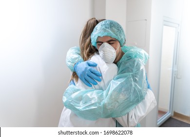 Coronavirus. Portrait Of Doctors And Nurses Hugging At Hospital And Fighting The Coronavirus. Doctors Are Heroes. Wearing Protective Suits And Masks. Great Team. Fellowship.