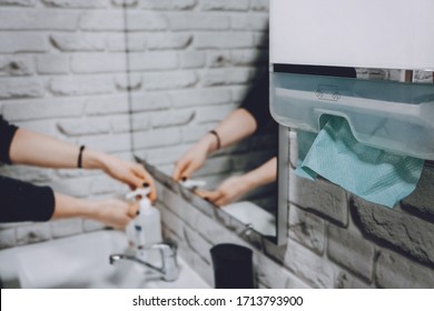 Coronavirus Protection Hand Hygiene. Paper Towels And Alcohol Gel Antibacterial Soap Sanitizer In Bathroom. Woman Washes Her Hands And Wipes With A Paper Towel.