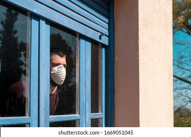 Coronavirus. Sick man of corona virus 
looking through the window and wearing mask protection and recovery from the illness in home. Quarantine. Patient isolated to prevent infection. Lockdown