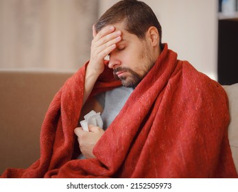 Coronavirus. Sick Man Of Corona Virus Lying Down In Sofa And Recovery From Illness In Home. Blowing His Nose. The Concept Of High Temperatures. The Person Is Seriously Ill.