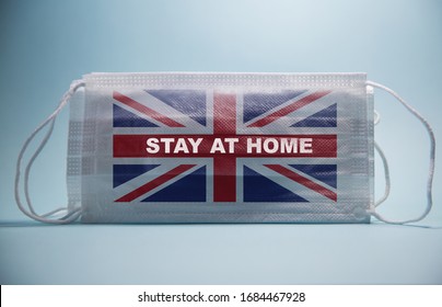 Coronavirus Stay At Home Warning Message And The Flag Of The UK Printed On A White Surgical Mask.Global Economy Hit By Corona Virus Outbreak And Pandemic