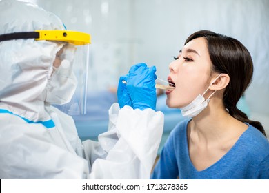 Coronavirus test - Medical worker taking a throat swab for coronavirus sample from a potentially infected woman with the isolation gown or protective suits and surgical face masks - Shutterstock ID 1713278365