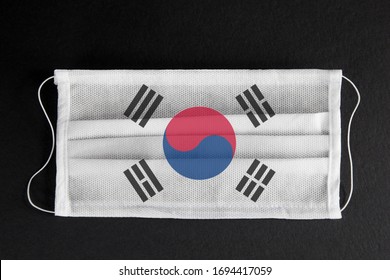 Coronavirus Update In South Korea. South Korean Healthcare Concept. Flag Of South Korea Printed On Medical Mask On Black Background. Covid-19 Outbreak.  Spread Of Corona Virus In Asia.