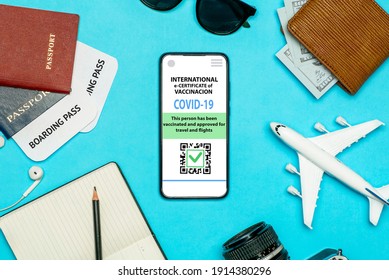 Coronavirus vaccination certificate or vaccine passport for travellers concept. COVID-19 immunity e-passport in the smartphone mobile app for international travelling. Blue background with toy plane 