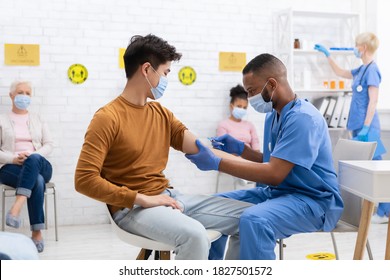 Coronavirus Vaccination. Chinese Patient Receiving Covid-19 Vaccine Injection During Doctor's Appointment In Clinic. Corona Virus Population Immunization Campaign, Covid 19 Medication Treatment