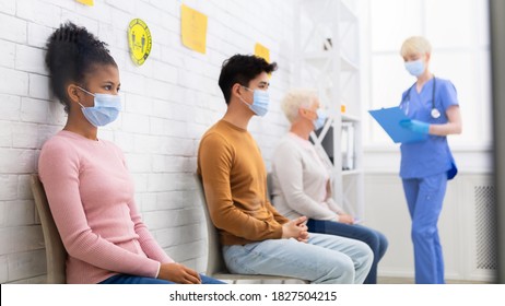 Coronavirus Vaccination Concept. Black Girl Waiting For Covid-19 Vaccine Sitting In Queue With Diverse People In Hospital Waiting-Room. Covid 19 Virus Prevention And Medical Treatment Concept