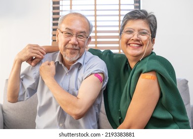 Coronavirus Vaccination, happy asian elderly, aged family smile strong together, showing bandage on arm with protect of covid-19 after injection of vaccine, sitting on couch in living room at home. - Powered by Shutterstock