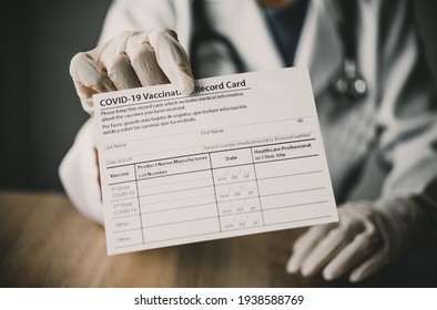 Coronavirus vaccination record card in the hands of a doctor to a patient who has already been vaccinated with Coronavirus. .Coronavirus prevention - Shutterstock ID 1938588769