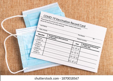 Coronavirus vaccination record card. Protective mask divided into two parts. Concept of defeating Covid-19 - Shutterstock ID 1870018567