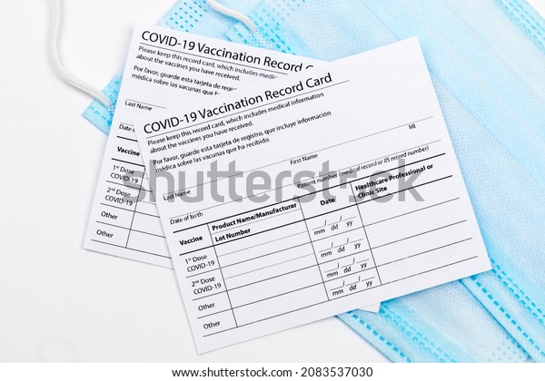 Coronavirus vaccination\
record card. Protective mask divided into two parts. Concept of\
defeating Covid-19
