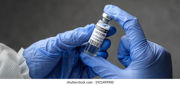 Coronavirus Vaccine In Doctor Hands, Panoramic Banner With Physician Holding Bottle Of COVID-19 Vaccine. Concept Of Health, Corona Virus Treatment, Vaccine Shot And Distribution During COVID Pandemic
