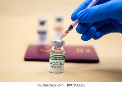 Coronavirus vaccine. Getting vaccinated for international travel. passport and vaccine bottle. doctor wearing gloves makes a vaccine with a syringe in his hand.
