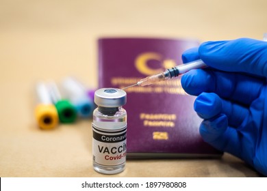 Coronavirus vaccine. Getting vaccinated for international travel. passport and vaccine bottle. doctor wearing gloves makes a vaccine with a syringe in his hand.
