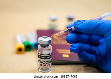 Coronavirus vaccine. Getting vaccinated for international travel. passport and vaccine bottle. doctor wearing gloves makes a vaccine with a syringe in his hand.
Selective Focus