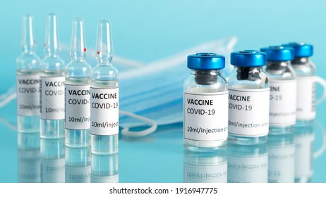 Coronavirus vaccine vial. Covid vaccination with vaccine glass bottles and ampoules. Blue background. Selective focus. - Shutterstock ID 1916947775
