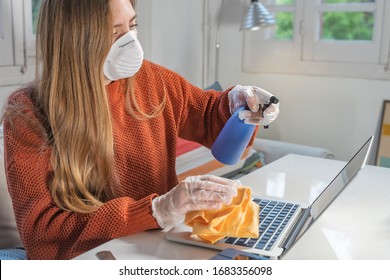 Coronavirus. Woman With Face Mask And Rubber Gloves Cleaning Her Work Space  With A Disinfectant At Home During The Coronavirus Epidemic. Prevention And Control Of Epidemic. Disinfect Your House.