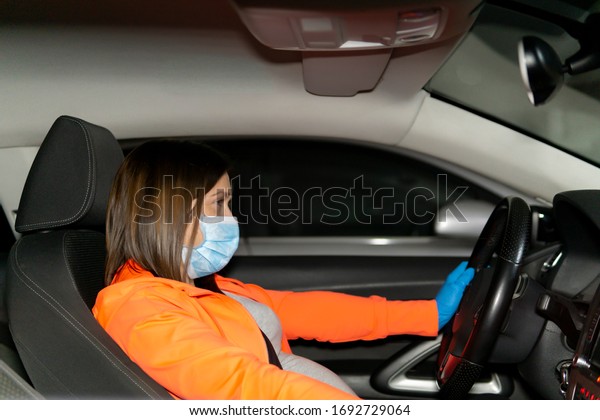 coronavirus.\
woman using security measures in her\
vehicle