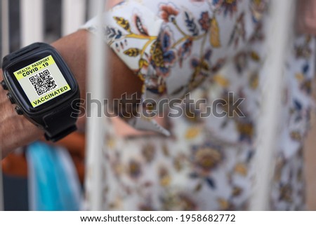 Coronavirus.Woman wearing wristwatch with a digital certificate of vaccination against Covid-19, health passport