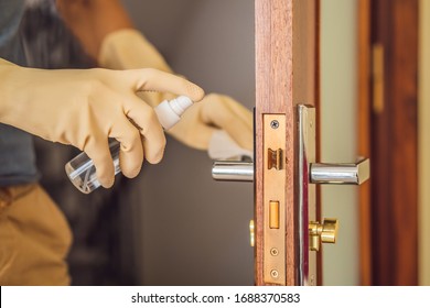 Coronovirus Prevention A Man Disinfects A Doorknob. Closeup Of A Caucasian Man Disinfecting The Door Handle By Spraying Sanitizer From A Bottle