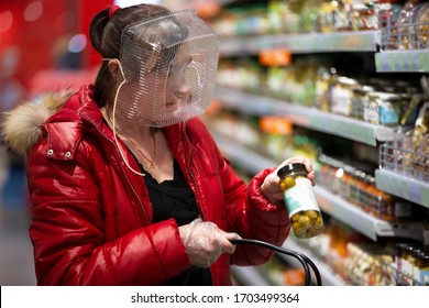 Coronovirus protection. Woman in a store with a plastic box on her face. A funny way to protect against COVID 19.Coronavirus and panic buying concept