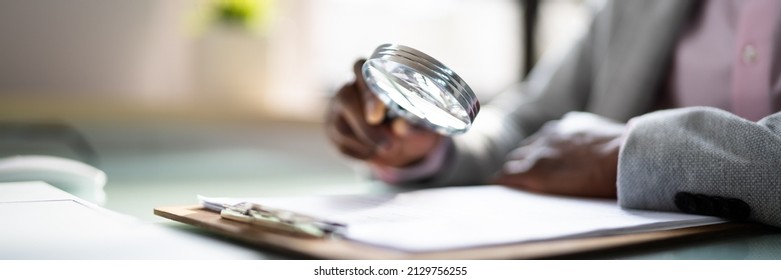 Corporate Auditor Using Magnifying Glass For Tax Fraud Audit