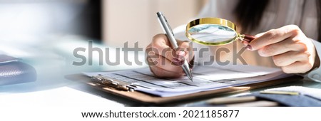 Corporate Auditor Using Magnifying Glass For Tax Fraud Audit