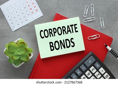 Corporate Bonds. A Green Bulletin Board Sticker On A Red Notepad And Assorted Stationery. Sticker Text