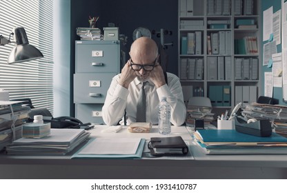 Corporate businessman having a sad desk lunch alone in the office - Powered by Shutterstock