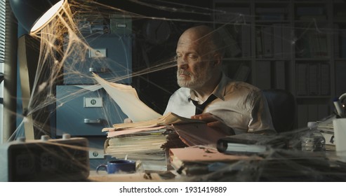 Corporate Businessman Searching For Paperwork In An Abandoned Office: Failure, Financial Crisis And Outdated Business Concept