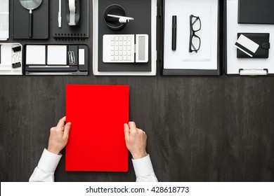 Corporate Businessman Working At Office Desk, He Is Holding A Folder, Business And Finance Concept, Flat Lay