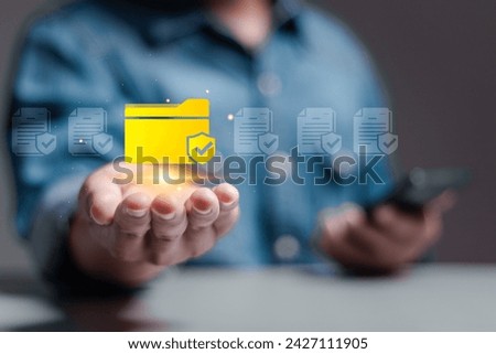 Corporate data management system concept. Personal data and corporate personal data protection. Person hold folder icon with shield protection on virtual screen for document secure confidential access