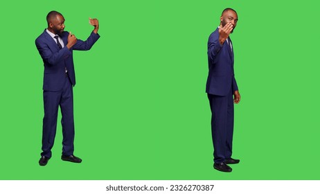 Corporate employee asking someone to come over, waving hand to call people over and accompany him. Male office worker wearing formal suit over full body green screen backdrop. - Powered by Shutterstock