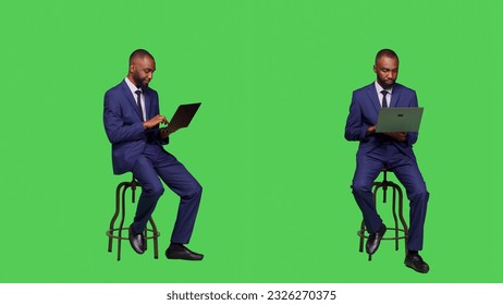 Corporate employee searching on online website, sitting on chair and using laptop in studio. Adult entrepreneur working with internet network page on wireless computer, full body greenscreen. - Powered by Shutterstock