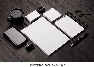 Corporate identity template,  blank stationery set with coffee and earphone on black stylish wood background. Mock up for branding, business presentations and portfolios.
