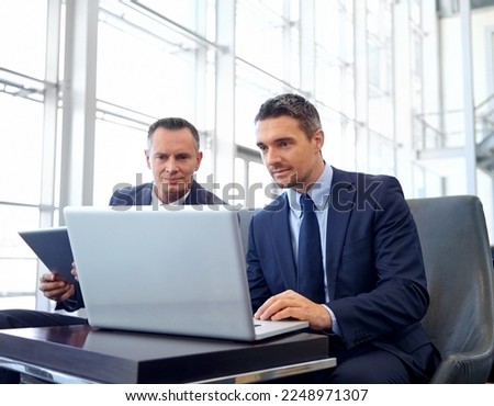 Corporate, laptop and business people in lobby meeting, collaboration or strategy planning on global marketing. Professional businessman, client or partner reading online review for company portfolio