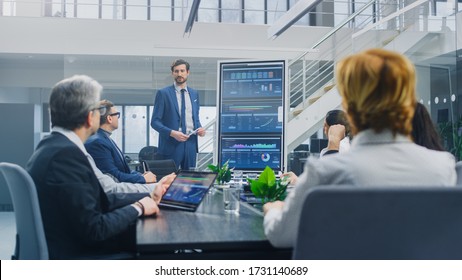 In The Corporate Meeting Room: Ambitious Executive Uses Digital Interactive Whiteboard For Presentation To A Board Of Directors, Lawyers, Investors. Screen Shows Company Growth Data With Digital Graph