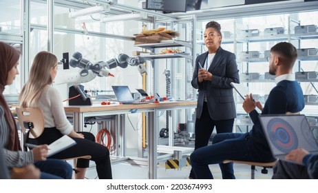 Corporate Meeting Room: Confident Black Female Engineer Talk With Intelligent Future Developers About Record Breakthrough In Robotics. Computer Science And Programming For Robotic Arm Concept.