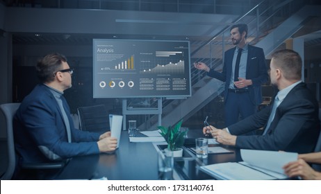 In the Corporate Meeting Room: Male Executive Talks and Uses Digital Interactive Whiteboard for Presentation to a Board of Directors, Investors. Screen Shows Growth Data. Late at Night Office - Shutterstock ID 1731140761