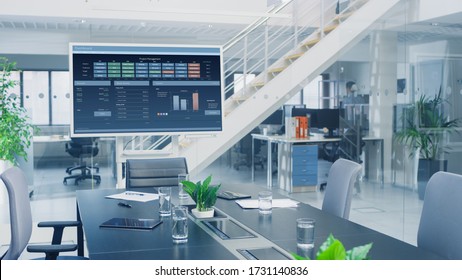 In The Corporate Office Meeting Room Stands TV Or Interactive Digital Whiteboard In Horizontal Mode With Future Company Plans. In The Background Big Bright Busy Office