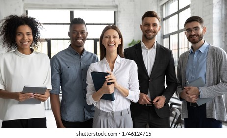 Corporate Portrait Successful Smiling Diverse Employees Team Standing In Office, Posing For Photo With Confident Businesswoman Team Leader Executive, Looking At Camera, Unity And Cooperation