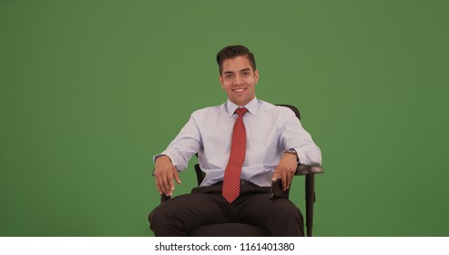 Corporate professional sitting in office chair looking at camera on green screen - Powered by Shutterstock
