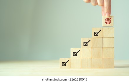 Corporate regulatory and compliance. Goals achievement and business success. Project and goals tracking. Task completion. Managing project timeline. Holding wooden cube with target achievement icon.