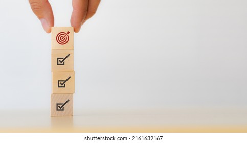 Corporate regulatory and compliance. Goals achievement and business success. Project and goals tracking. Task completion. Managing project timeline. Holding wooden cube with target achievement icon. - Shutterstock ID 2161632167