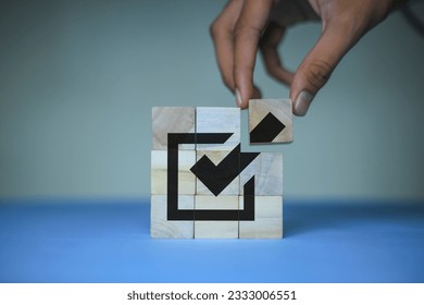 Corporate regulatory and compliance. Goals achievement and business success. Task completion. Ethical corporate. Do the right thing. Quality and ISO symbol. Placing wooden cube with checkmark icon
