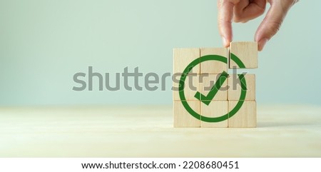 Corporate regulatory and compliance. Goals achievement and business success. Task completion. Ethical corporate. Do the right thing. Quality and ISO symbol. Wooden cube with green checkmark icon.