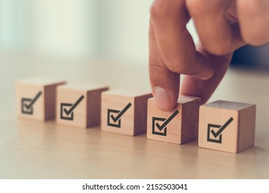 Corporate regulatory and compliance. Quality control management, ISO certification. Product, service quality warranty. Checklist survey and assessment  process. Put wooden cube with check mark icon. - Shutterstock ID 2152503041