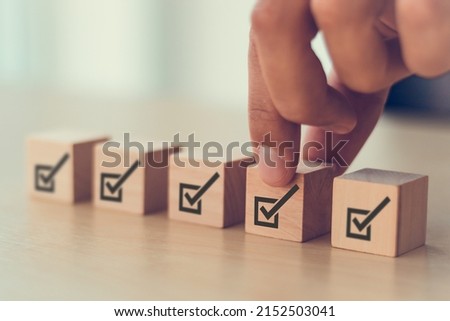Corporate regulatory and compliance. Quality control management, ISO certification. Product, service quality warranty. Checklist survey and assessment  process. Put wooden cube with check mark icon.