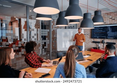 In a corporate setting businessman leads a meeting, passionately presenting a business plan to his attentive team, fostering collaboration and strategic thinking - Powered by Shutterstock